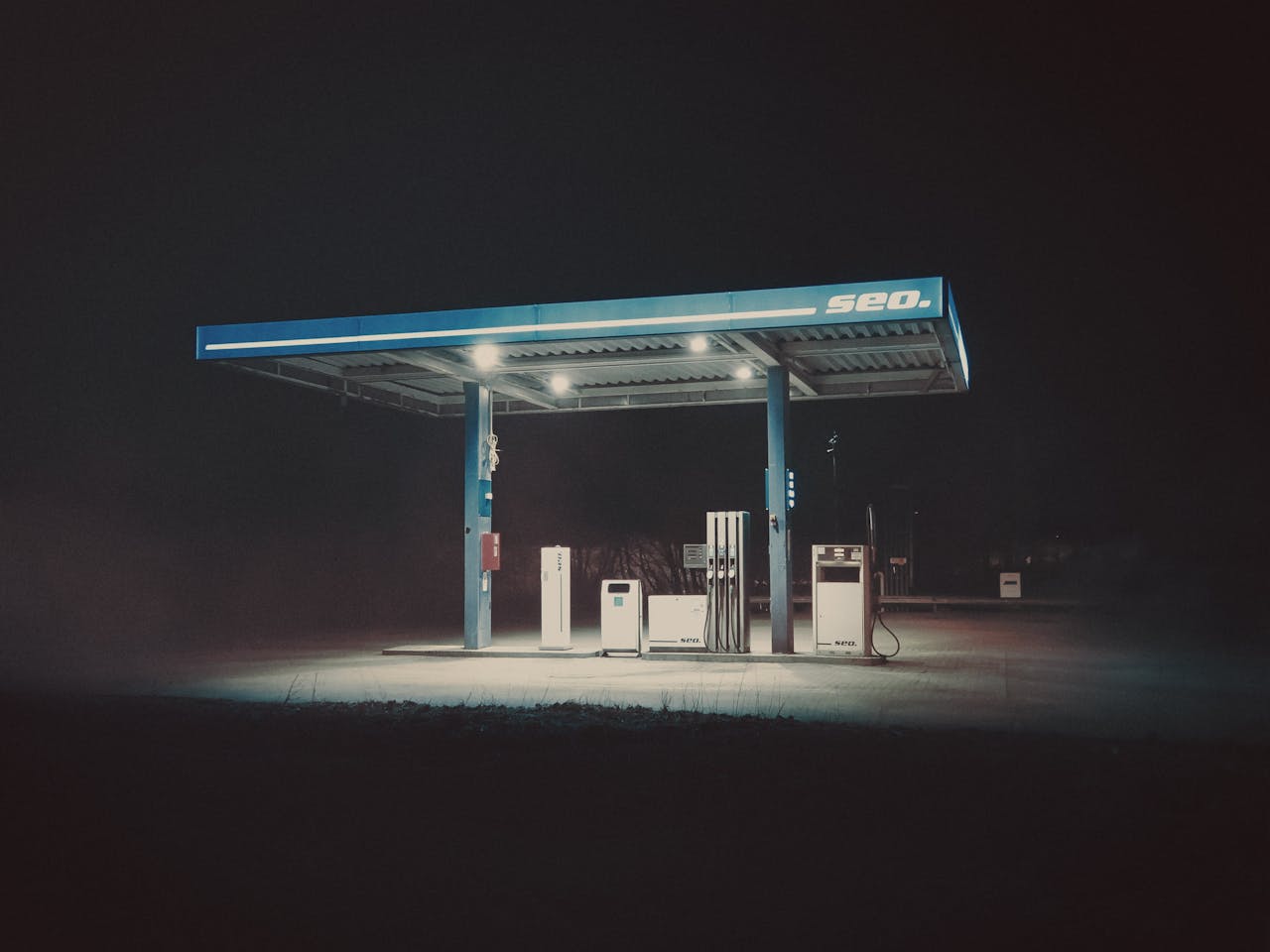 gallery-01 A dimly lit gas station under a dark sky evokes a mysterious and eerie atmosphere.